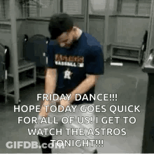 A Man Is Dancing In A Locker Room While Wearing A Blue Shirt And A Hat . GIF