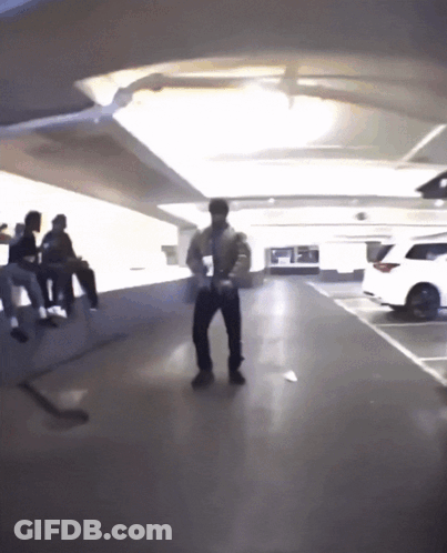 A Man Is Dancing In A Parking Garage GIF