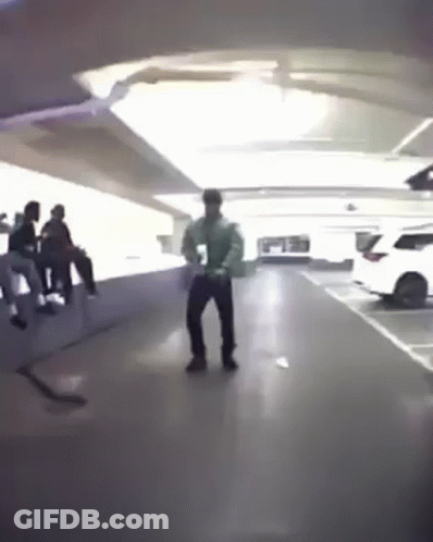 A Man Is Dancing In A Parking Garage With A Group Of People . GIF
