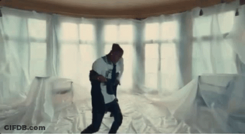 A Man Is Dancing In A Room Covered In White Cloth GIF