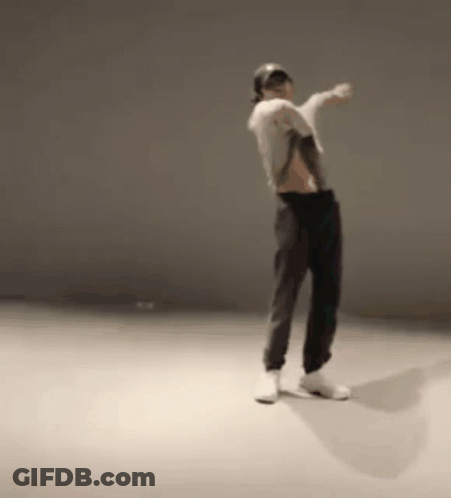 A Man Is Dancing In A Room With A Hat On . GIF