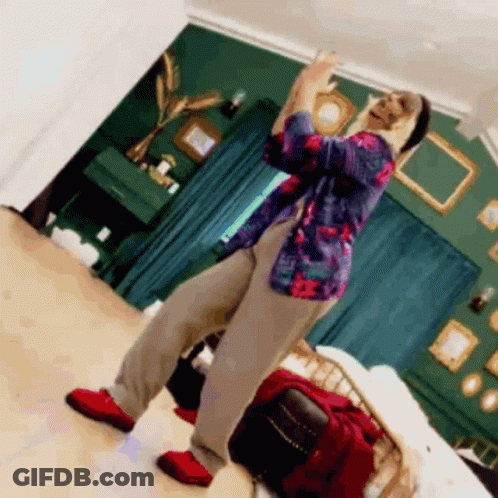 A Man Is Dancing In A Room With Green Walls GIF