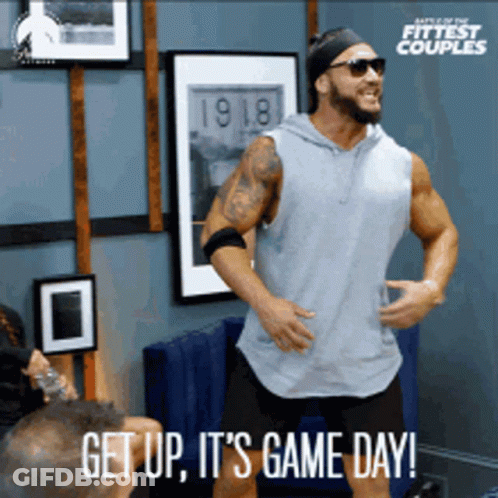 A Man Is Dancing In A Room With The Words Get Up It 'S Game Day Below Him GIF