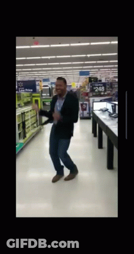 A Man Is Dancing In A Store With A Sign That Says $ 248 GIF