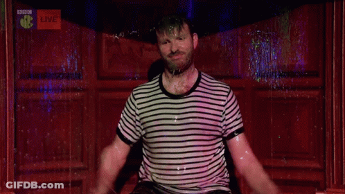 A Man Is Dancing In Front Of A Bbc Live Sign GIF
