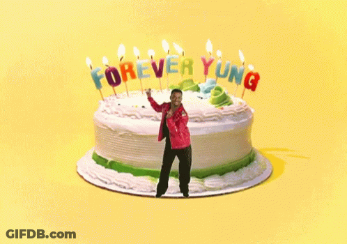 A Man Is Dancing In Front Of A Birthday Cake That Says Forever Young GIF