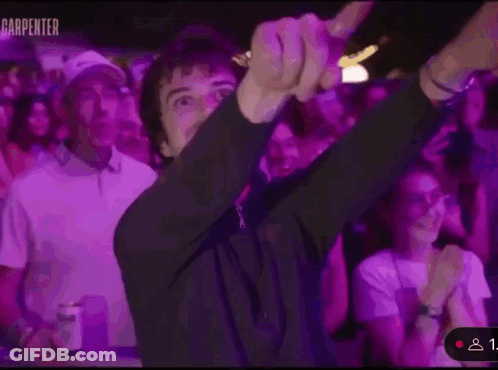 A Man Is Dancing In Front Of A Crowd Of People At A Party . GIF