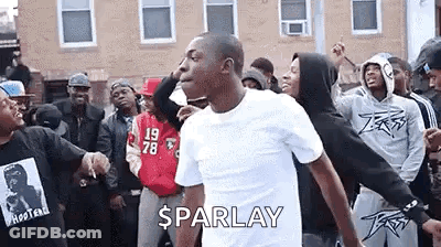A Man Is Dancing In Front Of A Crowd Of People . GIF