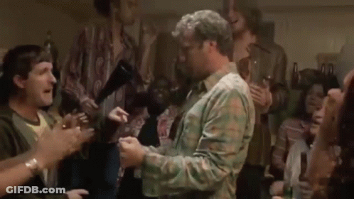 A Man Is Dancing In Front Of A Crowd Of People . GIF