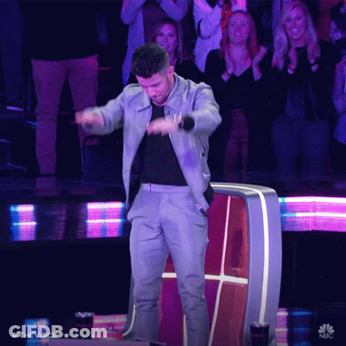 A Man Is Dancing In Front Of A Crowd With The Hashtag #Thevoice On The Bottom GIF