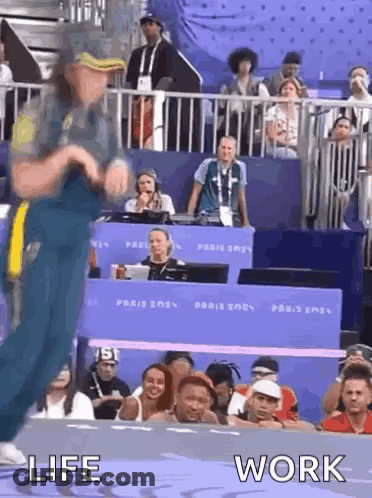 A Man Is Dancing In Front Of A Crowd With The Words Life And Work Written Below Him . GIF