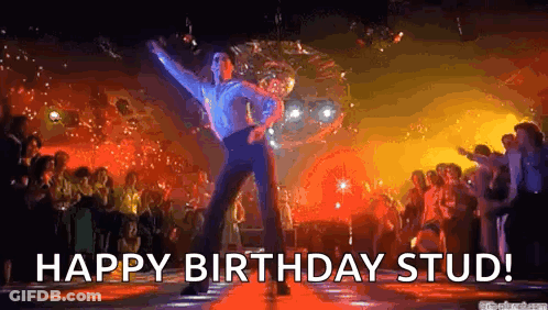 A Man Is Dancing In Front Of A Disco Ball In A Nightclub . GIF