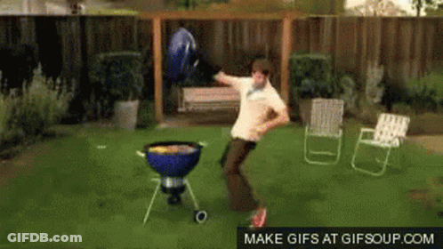 A Man Is Dancing In Front Of A Grill In A Backyard GIF