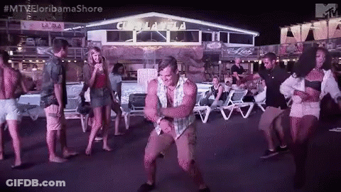 A Man Is Dancing In Front Of A Group Of People At A Party . GIF