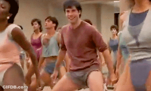 A Man Is Dancing In Front Of A Group Of Women In A Gym . GIF