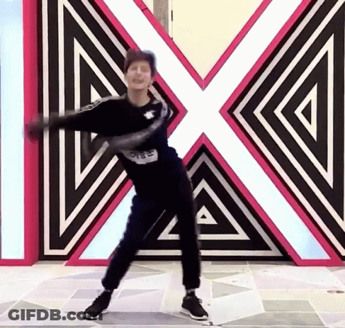 A Man Is Dancing In Front Of A Large X On The Wall GIF