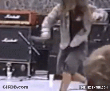 A Man Is Dancing In Front Of A Marshall Amplifier . GIF