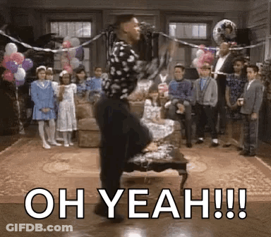 A Man Is Dancing In Front Of A Microphone In A Living Room While A Group Of Children Watch . GIF