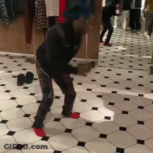 A Man Is Dancing In Front Of A Mirror In A Room GIF