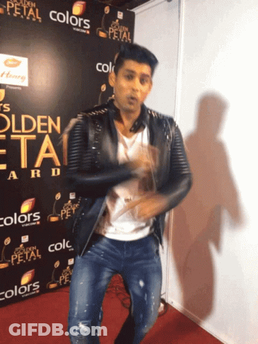 A Man Is Dancing In Front Of A Sign That Says Golden Petal GIF