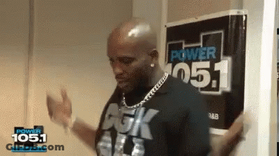 A Man Is Dancing In Front Of A Sign That Says Power 105.1 GIF