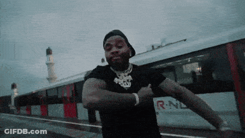 A Man Is Dancing In Front Of A Train That Says R-Nl GIF