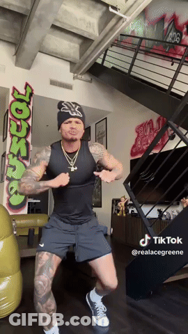 A Man Is Dancing In Front Of A Wall With Graffiti That Says ' Ross ' GIF