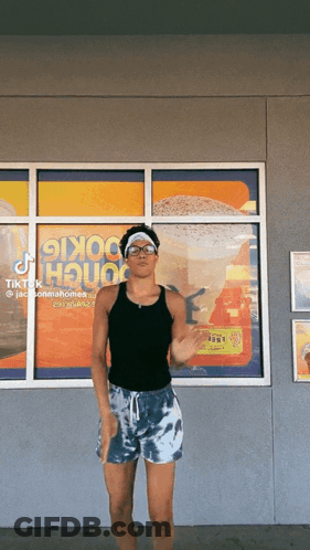 A Man Is Dancing In Front Of A Window That Says ' Cookie House ' On It GIF