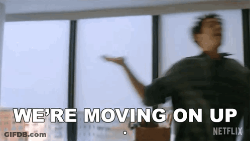 A Man Is Dancing In Front Of A Window With The Words `` We 'Re Moving On Up '' Written On The Bottom . GIF