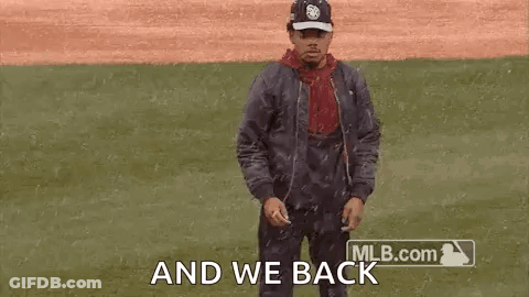 A Man Is Dancing On A Baseball Field While Wearing A Hat And A Jacket . GIF