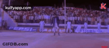 A Man Is Dancing On A Basketball Court In Front Of A Crowd Of People . GIF