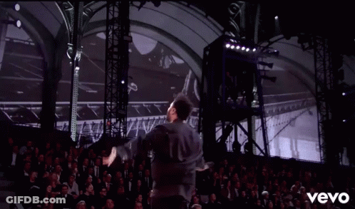 A Man Is Dancing On A Stage In Front Of A Crowd And The Word Vevo Is On The Bottom Of The Screen GIF