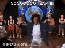 A Man Is Dancing On A Stage In Front Of A Group Of People And A Globe . GIF