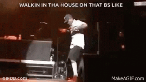 A Man Is Dancing On A Stage In Front Of A Microphone . GIF