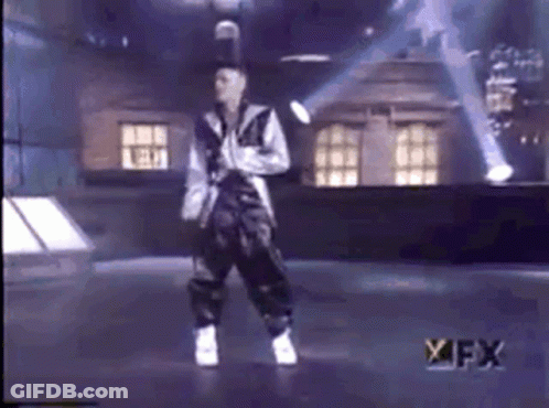 A Man Is Dancing On A Stage In Front Of A Sign That Says Fx GIF