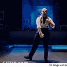 A Man Is Dancing On A Stage With A Memeguy.com Watermark On The Bottom GIF