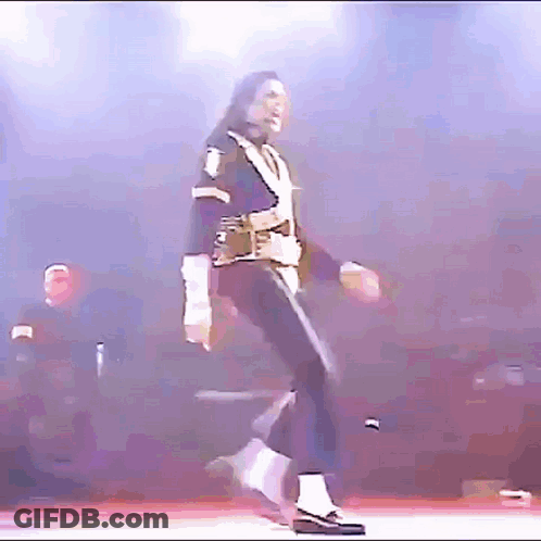A Man Is Dancing On A Stage With A Purple Background . GIF