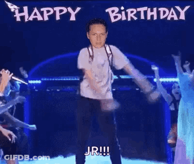 A Man Is Dancing On A Stage With The Words `` Happy Birthday Jr '' Written On The Background . GIF