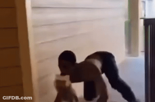 A Man Is Doing A Handstand In A Doorway While Holding A Bottle Of Water . GIF