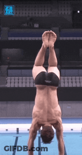 A Man Is Doing A Handstand In A Pool With A Speedo Logo On The Bottom Right GIF