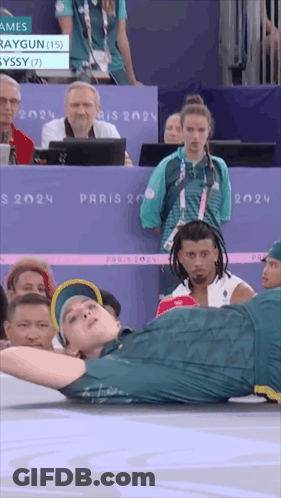A Man Is Doing A Handstand In Front Of A Crowd At The Paris 2024 Olympics GIF