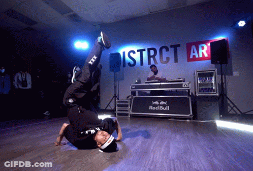A Man Is Doing A Handstand In Front Of A Sign That Says District Ar GIF