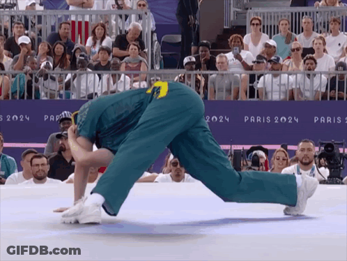 A Man Is Doing A Handstand In Front Of A Sign That Says Paris 2024 On It GIF