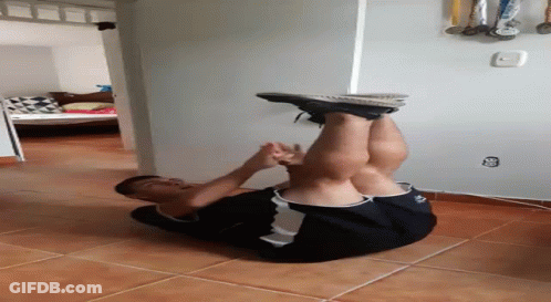 A Man Is Doing A Handstand On A Tile Floor In A Room . GIF
