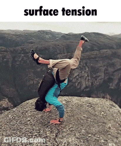 A Man Is Doing A Handstand On Top Of A Rock With The Words Surface Tension Behind Him GIF