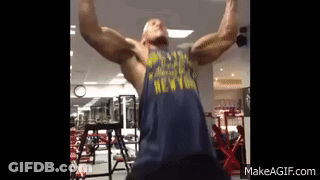 A Man Is Doing A Pull Up In A Gym Wearing A New York Shirt . GIF