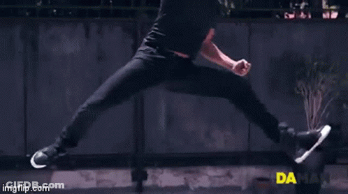 A Man Is Doing A Trick In Front Of A Fence And A Sign That Says Daman GIF