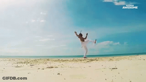 A Man Is Doing A Yoga Pose On A Beach With The Words Awesome Behind Him GIF