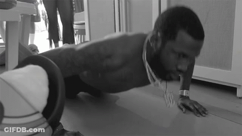 A Man Is Doing Push Ups On The Floor While Wearing A Watch GIF