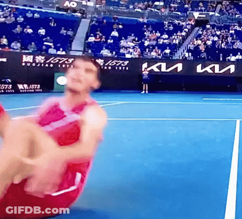 A Man Is Doing Sit Ups On A Tennis Court With A Kia Sign In The Background . GIF